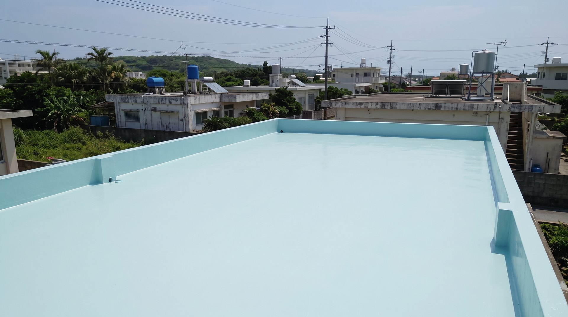 うすい水色に塗り上がった、コンクリートの平らな屋根（イメージ）